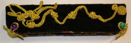 Fülleretui aus Samt, mit appliziertem Drachenknoten aus Goldsoutache. Verschlossen mit einer Amethyst- und einer Malachitperle.