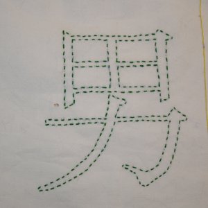 Beispiel für einfachen Vorstich: Das Kanji für Mann in dunkelgrünem Vorstich. Vorlage in Pinselschrift.